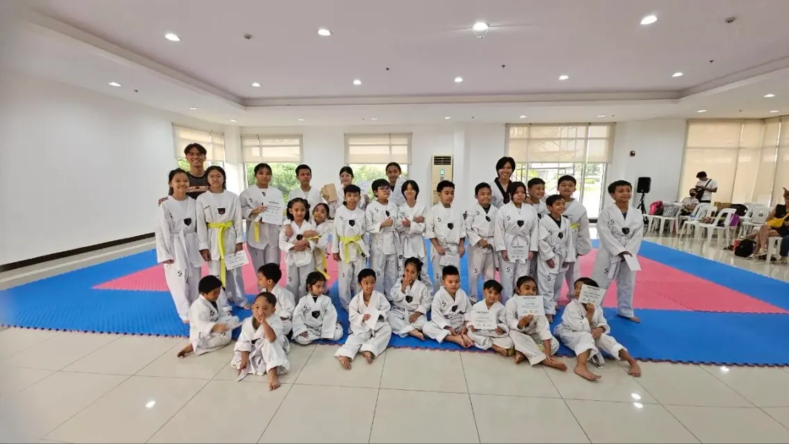 The whole school gathered for a group photo, several students holding grading certificates